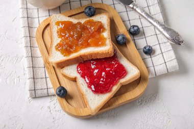 Ahşap tahta tost tahtası ve grunge beyaz arka planda reçeller.