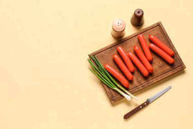 Lezzetli ince sosisli pano ve bej arka planda yeşil soğan.