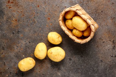 Siyah arka planda çiğ bebek patatesli hasır sepet