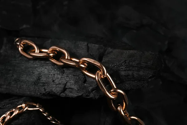 stock image Beautiful chain bracelets on black charcoal, closeup