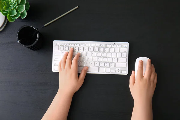 stock image Female programmer using computer keyboard and mouse on dark wooden background