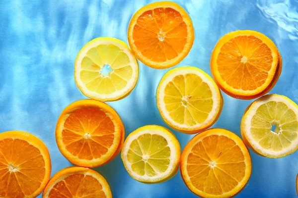 Plátky Čerstvé Pomeranče Citronu Vodě Modrém Pozadí — Stock fotografie