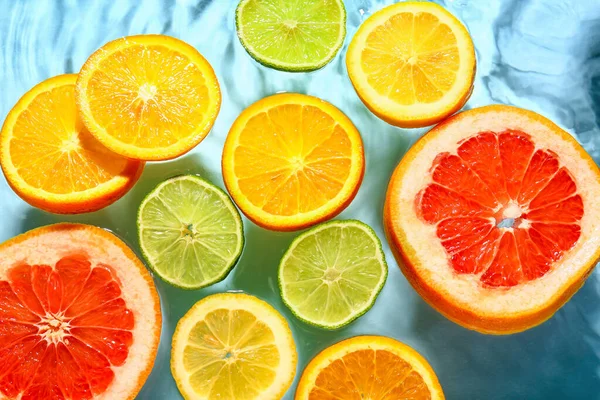 Různé Plátky Citrusových Plodů Vodě Modrém Pozadí — Stock fotografie