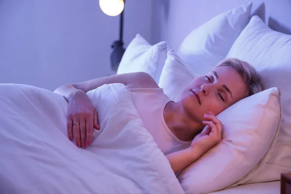 夜にベッドで寝てる若い女性 — ストック写真