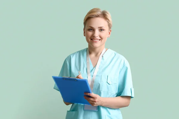 Female Medical Intern Clipboard Green Background — стоковое фото