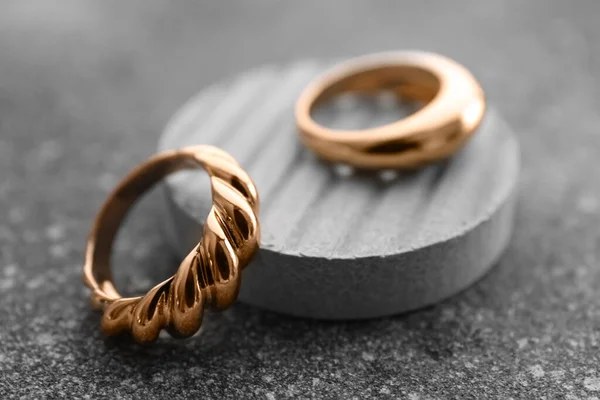 Dekoratív Dobogó Gyönyörű Arany Gyűrűk Grunge Szürke Háttér — Stock Fotó