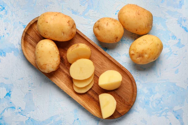 Holzbrett Mit Rohen Kartoffelscheiben Auf Blauem Hintergrund — Stockfoto
