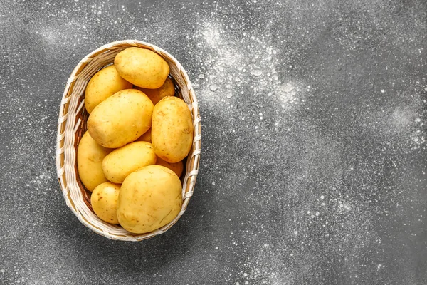 stock image Wicker bowl with raw baby potatoes on grey background