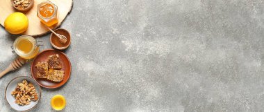Gri arkaplanda tatlı bal, limon ve cevizli kompozisyon metin ve üst görünüm için boşluk