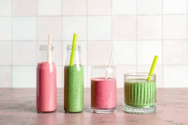 Gözlükler ve pembe masada renkli meyve püresi.