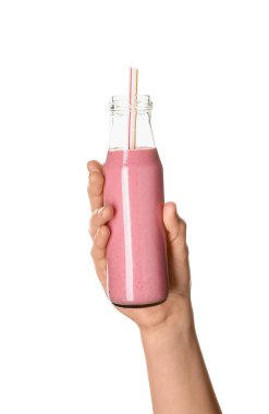 Beyaz arka planda cam şişe pembe smoothie ile kadın eli.