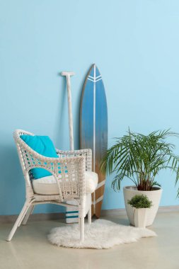 Oturma odasının içinde sörf tahtası, kürek ve koltuk var.