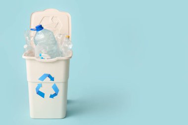 Açık mavi arka planda plastik olan çöp konteynırı. Geri dönüşüm kavramı