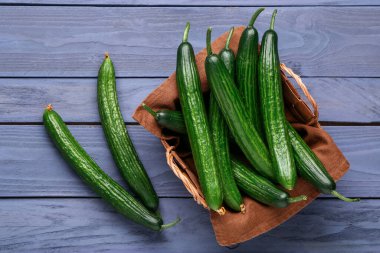 Gri ahşap arka planda taze salatalıklı sepet.