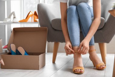 Mağazada şık yüksek topuklu sandaletler deneyen bir kadın.