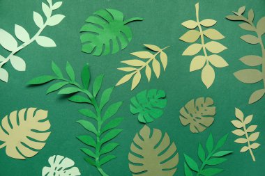 Yeşil arkaplanda güzel origami yaprakları
