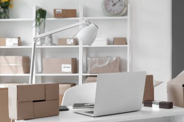 Ofiste dizüstü bilgisayarı ve paketleri olan bir işyeri