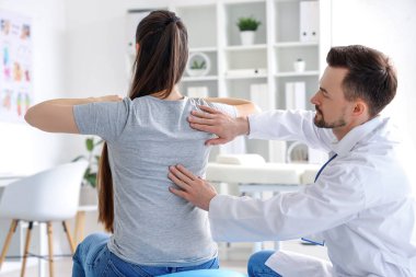Genç bir kadınla rehabilitasyon merkezinde çalışan erkek fizyoterapist.