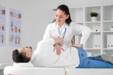 Rehabilitasyon merkezinde genç bir adamla çalışan kadın fizyoterapist.