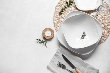 Süslü masa ayarı ve grunge beyaz arkaplan üzerinde mum ile hasır mat