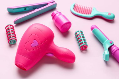 Pembe arka planda bir set kuaför aksesuarı. Çocuk Bayramı kutlaması