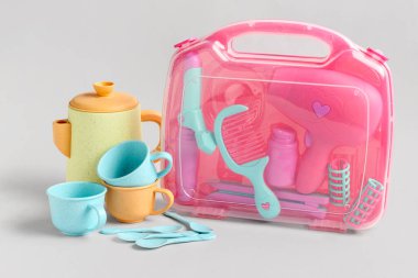 Gri arka planda çaydanlığı ve fincanı olan bir takım kuaför aksesuarı. Çocuk Bayramı kutlaması