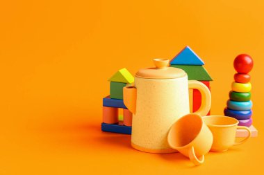 Turuncu arka planda farklı renkli oyuncaklar. Çocuk Bayramı kutlaması