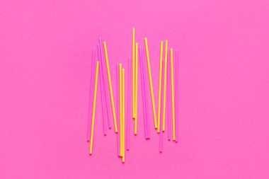 Pembe arka planda farklı plastik pipetler