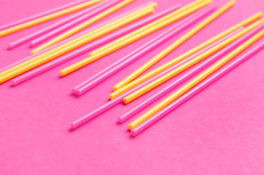 Pembe arka planda farklı plastik pipetler