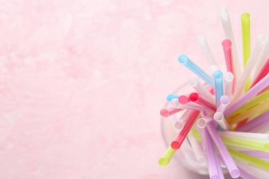 Grunge pembe arka planda farklı renkli pipetlere sahip cam
