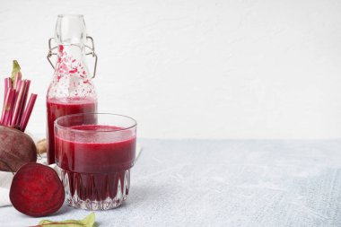 Hafif arka planda bir şişe taze pancar suyu.