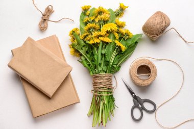 Güzel karahindiba çiçekleri, halat, makas ve açık arkaplan üzerine kitaplar.