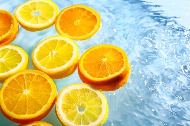 Mavi zemin üzerinde taze portakal ve limon dilimleri