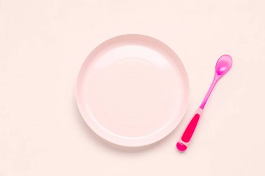 Pembe arka planda bebek için kaşıklı tabak