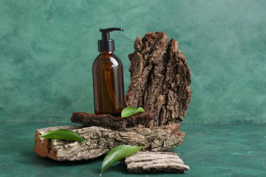 Kozmetik ürün şişesi, ağaç kabuğu ve bitki yapraklarıyla renklendirilmiş kompozisyon