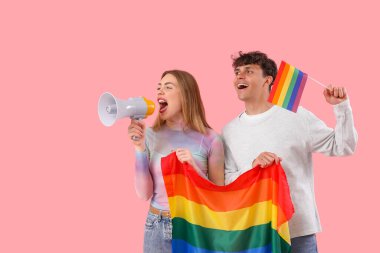 Pembe arka planda LGBT bayrakları ve megafonu olan genç bir çift.