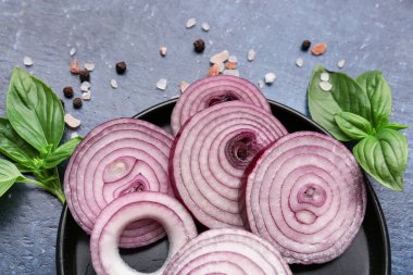 Mavi arka planda taze soğan ve baharat tabağı, yakın plan.