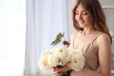 Mutfakta şakayık çiçekleri olan güzel bir kadın.