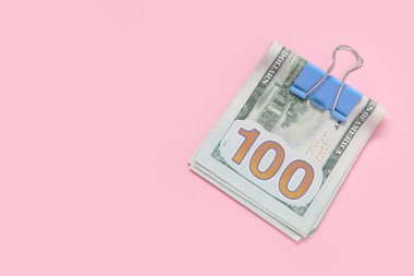 Pembe arka planda ciltli 100 dolarlık banknotlar.