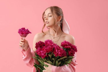 Pembe arka planda şakayık çiçekleri olan güzel bir kadın.