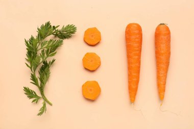 Turuncu arka planda taze havuç ve dilimler.