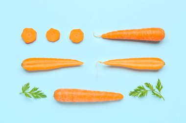 Turkuaz arka planda taze havuç ve dilimler.