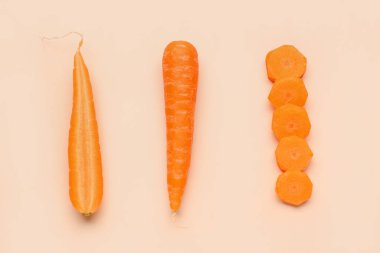 Turuncu arka planda taze havuç ve dilimler.