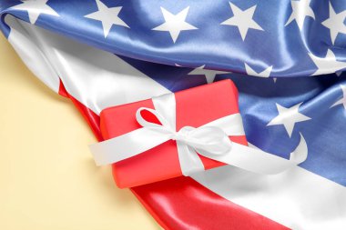 Soluk sarı arka planda ABD bayrağı olan hediye kutusu. Amerikan Bağımsızlık Günü