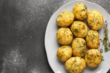 Gri arka planda dereotlu haşlanmış bebek patatesler.