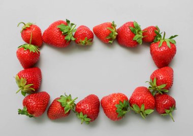 Gri arkaplanda taze çileklerden yapılmış çerçeve