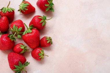 Pembe arka planda bir sürü taze çilek