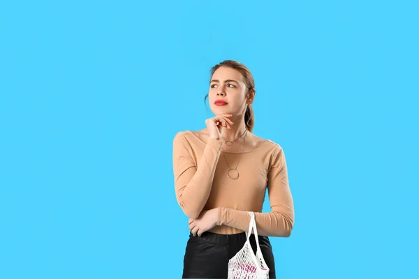 Nachdenkliche Junge Frau Mit Saitentasche Auf Blauem Hintergrund — Stockfoto