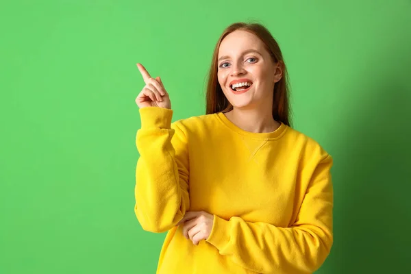 Jonge Roodharige Vrouw Sweatshirt Wijzend Iets Groene Achtergrond — Stockfoto