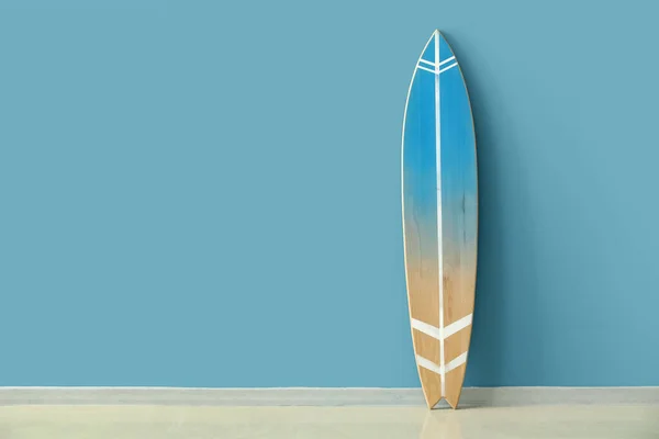 青い壁の近くに木製のサーフボード — ストック写真